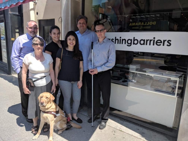 Sophie, Sarah and CNIB members and staff in front of the new CNIB hub in Toronto.